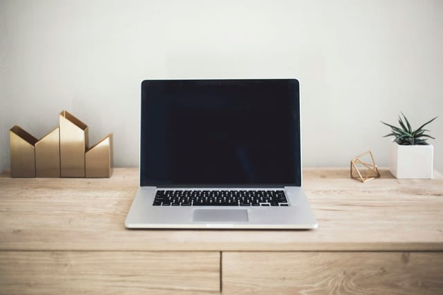 An open laptop on a simple desk