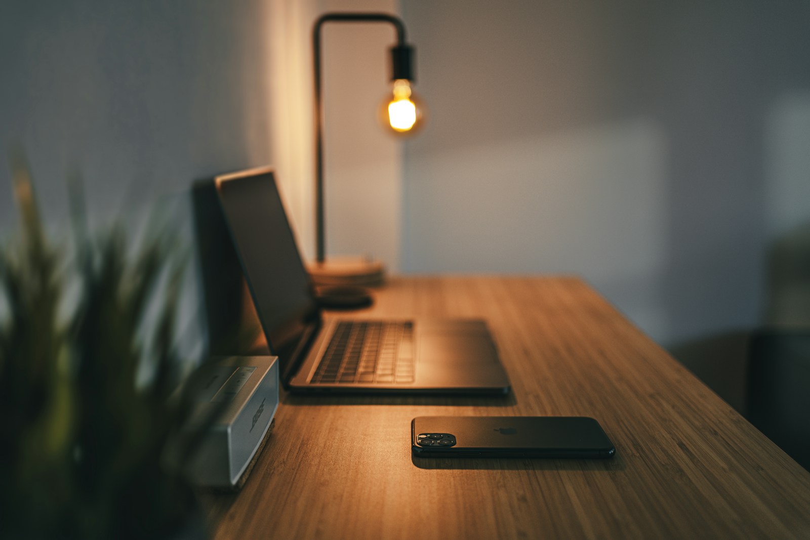 A laptop and task lamp arranged on a working desk