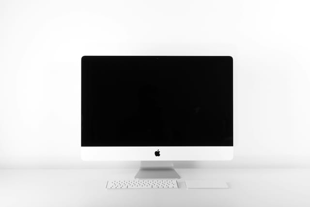 A desktop monitor and accessories on a working desk