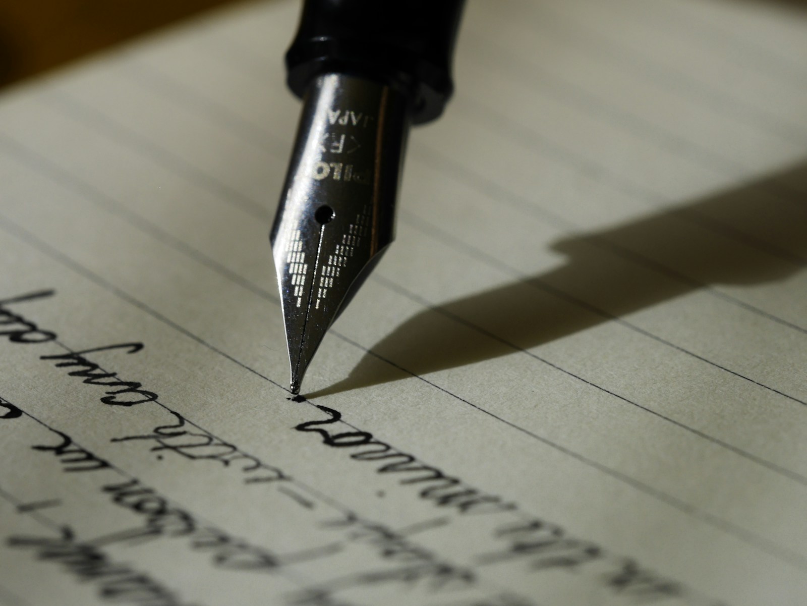 A notebook and pen in use on a desk